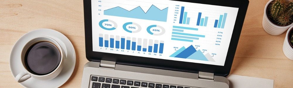 escritorio con computador portátil con gráficos de métricas sociales en pantalla