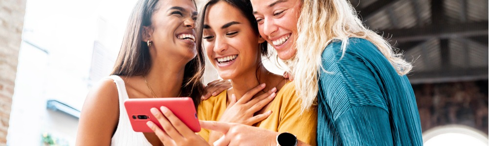 grupo de amigas viendo redes sociales en smartphone